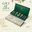 Le Souri Signature Chocolate Box with assorted chocolates and foil-wrapped bars inside an open green box.
