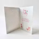 Open birthday card with "Happy Birthday" text and illustrations of a party hat and gift boxes.