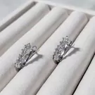 Sparkling 3MM moissanite diamond drop earrings with omega clip closure on white velvet display.