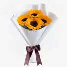Bouquet of four sunflowers with dark centers and yellow petals, wrapped in white paper and tied with a brown ribbon.