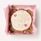 Chocolate chip cookies arranged around a large white iced cookie with "Happy Mother's Day" written on it.