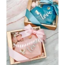 Two heart-shaped chocolate gift boxes, one pink, one blue, tied with ribbons, with "love" inscribed.