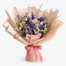 Bouquet of dried white, purple, and pink statice with violet caspia, wrapped in pink paper with a pink ribbon.