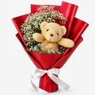 Teddy bear with white dry limonium in red bouquet wrap, tied with white ribbon.