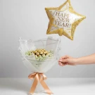 Ferrero Rocher bouquet with white gypsophilia, wrapped in white paper and tied with a peach ribbon, topped with a "Happy New Year" star balloon.