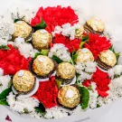 Bouquet of red carnations, white statice, and Ferrero Rocher chocolates.