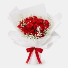 Bouquet of 24 red roses with white baby's breath, wrapped in white paper and tied with a red ribbon.