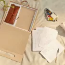 Gift box with custom coloring set, notebook, and tan leather roll.