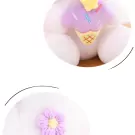 White plush rabbit wearing a purple ice cream cone hat, with a purple crocheted flower on its chest.