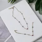 Gold-tone necklace and bracelet set with small colorful gemstones.