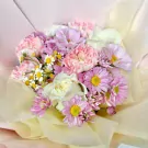 Pink daisy mums, white roses, and chamomile in a blush-toned bouquet.