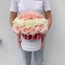Round white box filled with 40 pastel pink and white roses, tied with a pink ribbon.