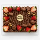 Chocolate brownie cake topped with strawberries, chocolate, and a "Happy Birthday" topper.