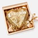 Golden heart-shaped chocolate with "Happy Birthday" text in a gift box with a hammer.