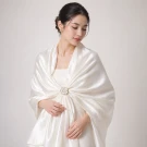 White scarf draped like a rose on a light gray background.