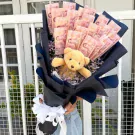 Money bouquet with teddy bear and dried flowers, ready for cash.