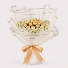 A bouquet of 19 Ferrero Rocher chocolates wrapped in white paper, adorned with white flowers and a gold ribbon.