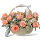 A woven basket filled with pastel pink roses, baby's breath, and dusty miller, tied with a white ribbon.