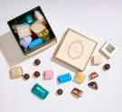 Le Souri chocolates in a gift box and scattered individually on a white surface.