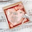 Pink heart-shaped chocolate gift box with "Happy Birthday" and "P MAI" in silver, a small hammer, and pink candy.