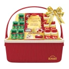 Red basket with gold ribbon holding Brand and Scott's Chicken Essence bottles and gift card.