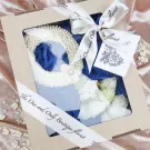 Jasmine garland in a gift box with white ribbon and roses.