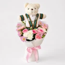 Graduation bouquet with a teddy bear in a Chula gown, surrounded by pink and white flowers and a pink ribbon.