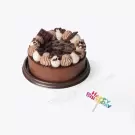 Chocolate cake with whipped cream, chocolate shavings, and chocolate bars, with a "Happy Birthday" topper.