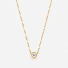 Gold chain necklace with a single, bezel-set moissanite diamond pendant.