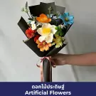 Artificial flowers in rainbow colors, wrapped in black paper with pink ribbon.