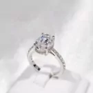 Oval-cut moissanite diamond ring with a white gold plated sterling silver band.