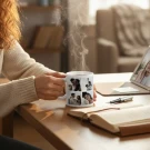 Mug with collage of couple's photos steaming in a woman's hands, with laptop and book nearby.
