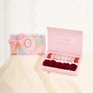 Pink chocolate box with preserved roses and chocolates, next to a matching gift box.