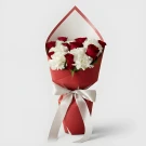 Bouquet of red roses and white carnations in red paper, tied with a silver ribbon.