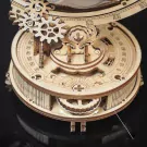Wooden globe model with gears, showing a rotating mechanism and circular dial.