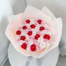 Bouquet of pink, red, and white roses with diamond centers, wrapped in sheer pink paper.