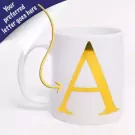 White ceramic mug with a large gold letter 'A' on the front.