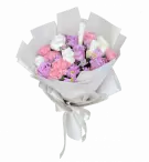 Bouquet of pink and purple roses, white roses, purple mums, and pink carnations with a white candle, wrapped in white paper and tied with a white ribbon.