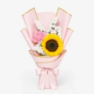 A pink bouquet with a sunflower, carnation, and greenery, tied with a pink ribbon.