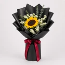 Sunflower, white statice, and eucalyptus bouquet wrapped in black paper, tied with a red ribbon.