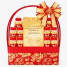Red gift basket with 10 bottles of health supplements, a gold book, and a large gold ribbon bow.