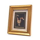Gold-framed art with a metal Garuda emblem on a black background.