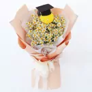Bouquet of daisies with a yellow stuffed grad bear wearing a black graduation cap.