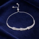 Silver chain bracelet with a curved row of clear, rectangular and round stones.