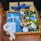 Gift basket with blue scarf, flowers, perfume, and artificial garland for Songkran.