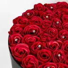 A box of red artificial roses with diamond accents.