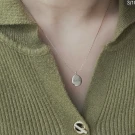 Silver oval pendant necklace engraved with "สมาธิ" in Thai script.