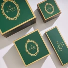 Green and gold Le Souri chocolate boxes in various sizes, with ornate gold logos.