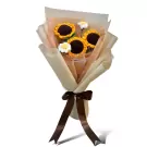 Crocheted bouquet of sunflowers and daisies with a brown ribbon, wrapped in light brown and cream paper.