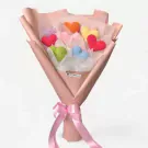 Crocheted heart bouquet in various colors wrapped in pink paper with a pink ribbon.